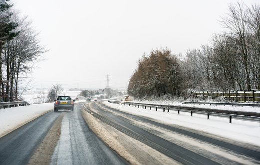 A driver's perspective on a January journey in Central Scotland, with snow on the surface of the motorway asphalt.