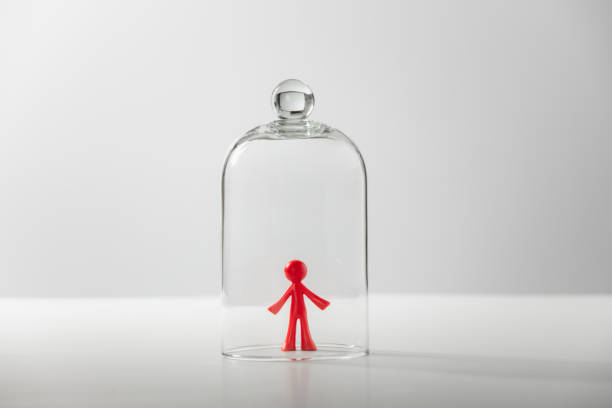 ガラスカバーの下の男のプラスチック製の姿 - 孤独、うつ病、孤立の概念 ストックフォト