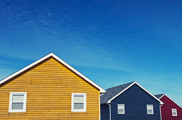 A trio of colourful cottages under blue skies.