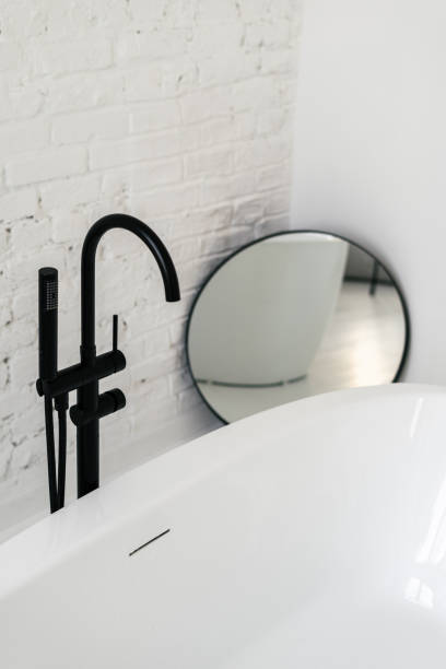 istock Mirror near ceramic bath with black faucet 1349433507