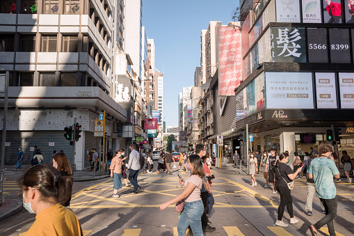 Hong Kong - October 26, 2021: Street view in Tsim Sha Tsui. People walking on the street and wearing mask to protect corona virus spread in air.Tsim Sha Tsui is a center of various shopping places