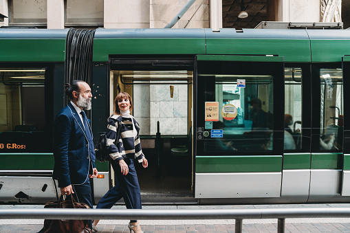 Business people are commuting to the office by tram. They are in Milan, Italy.