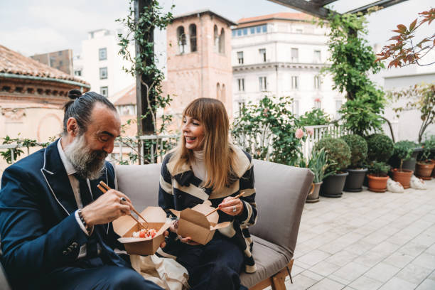 un couple d’hommes d’affaires d’âge mûr prend une pause déjeuner du bureau - eating men food chopsticks photos et images de collection