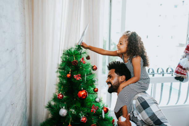 istock father and daughter preparing christmas tree 1349437796
