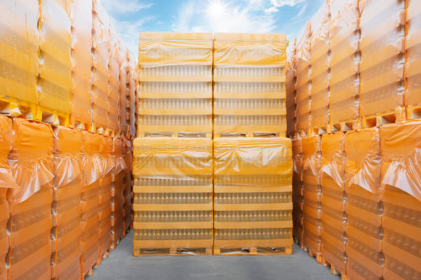 palets con botellas cubiertas con celofán naranja - industry warehouse floor beer fotografías e imágenes de stock