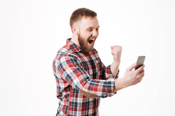 istock Screaming Bearded man in shirt using smartphone 1349441859