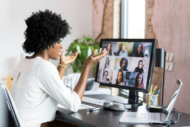 istock Using laptop and desktop PC, businesswoman meets virtually with colleagues 1349443309