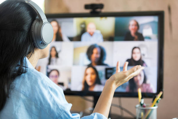 istock Rear view woman leading virtual meeting with multi-ethnic group 1349443327