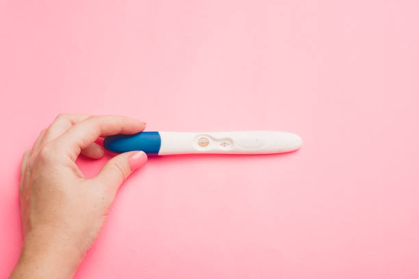 istock Pregnancy test in hand on a pink background . Positive test. Pregnancy copy space. 1349445191