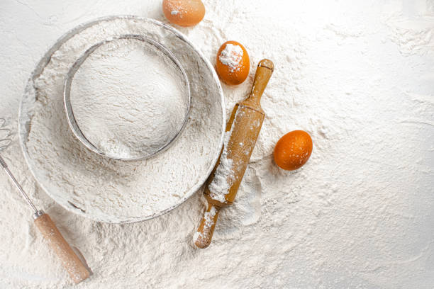 istock Sieve, a rolling pin and an egg on the table. Top view. 1349446938