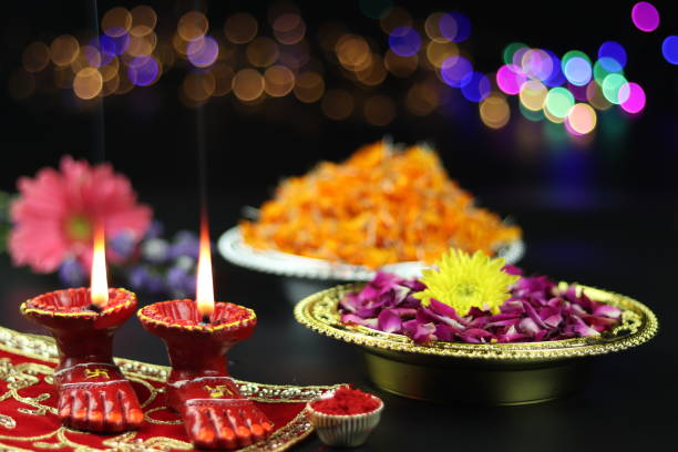 lâmpada de argila conhecida como diya, deep, diyo, deepa ou deepam with goddess feet lakshmi charan iluminando em asan de pano vermelho com flores roli sindoor e efeito bokeh. tema de shubh deepawali e laxmi pooja - diyo - fotografias e filmes do acervo