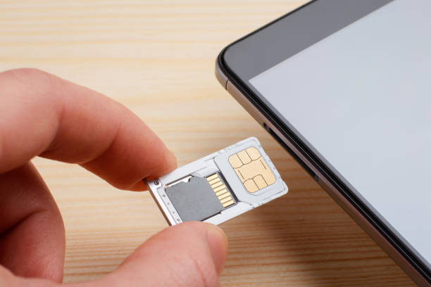 Man inserting tray for SIM card and micro SD memory card to the mobile phone.