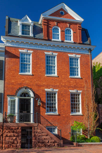 Red Brick House (Townhouse or Rowhouse) in Georgetown, Washington DC, USA. Clear Blue sky is in background. Canon EF 24-105mm/4L IS USM Lens.