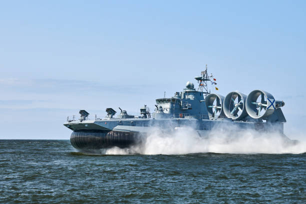 Landing Craft Air Cushion hovercraft flying above water, air cushion sailing splashing sea water Landing Craft Air Cushion LCAC hovercraft landing craft sailing splashing sea water at high speed. Hover craft flying above water, air cushion sailing near port at Baltic Sea. Russian Navy amphibious vehicle stock pictures, royalty-free photos & images