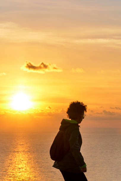 istock Woman hiking while sunrise over the sea 1349456372