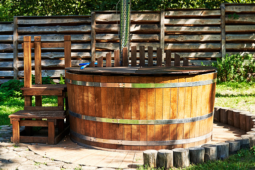 Modern wooden hot tub with stairs in garden outdoor, copy space. Wooden pool, Hot Tub, outdoor hot tub, spa