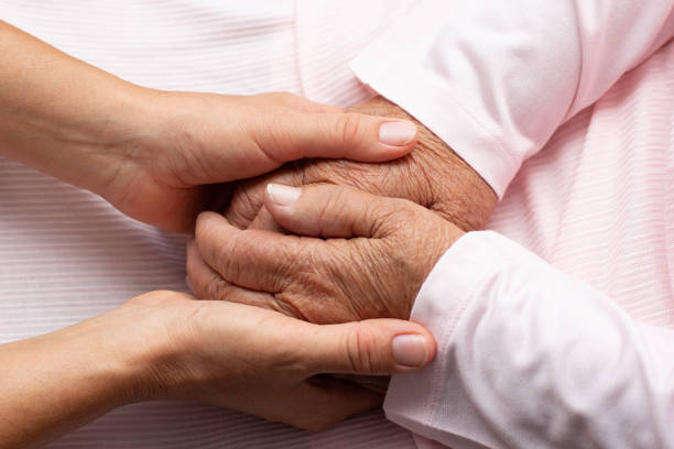istock Old and young holding hands support help old people on light background, closeup 1349458999