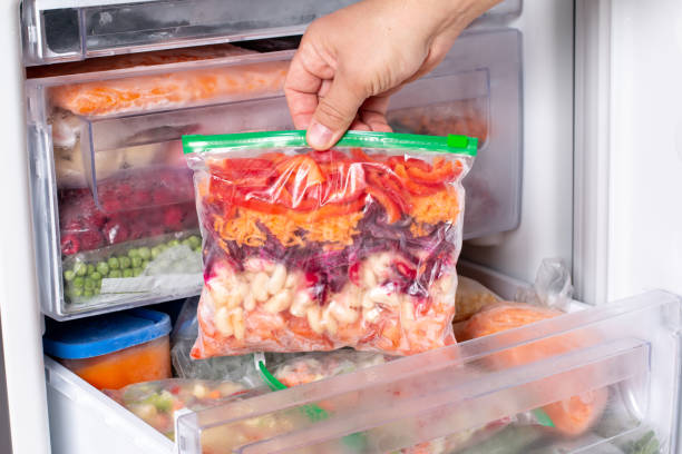 istock Plastic bags with different frozen vegetables in refrigerator. 1349459864