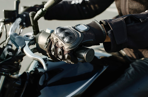female hand in motorcycle protective gloves holds a motorcycle, close-up