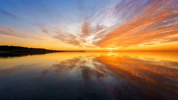 istock Orange sunset on a quiet lake, sunset reflected in calm water 1349462636