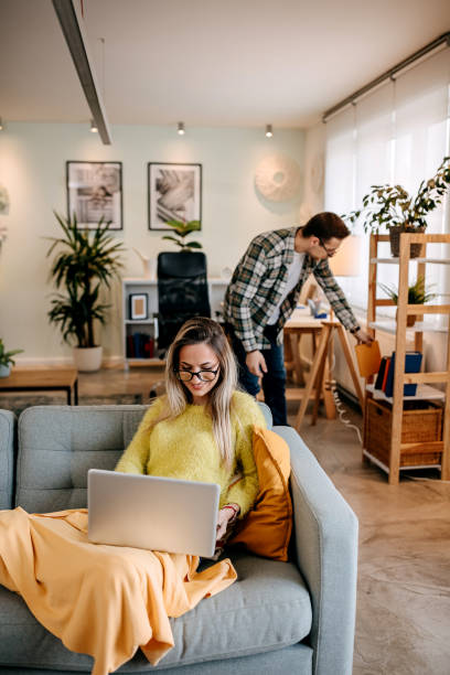 istock Couple using laptop and reading a book at home 1349462977