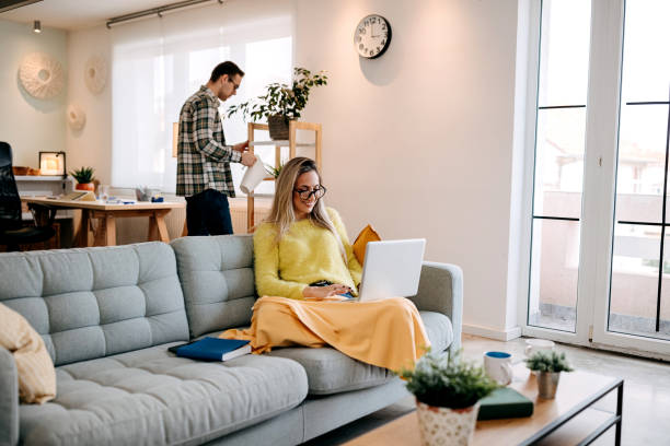 istock Couple using laptop and reading a book at home 1349462993