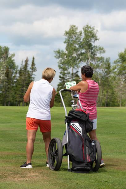frauen genießen zusammen vor dem golfspielen - golf cart concepts anticipation clothing stock-fotos und bilder