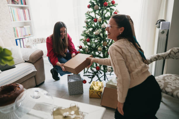 istock Two women placing presents under a Christmas tree 1349465295