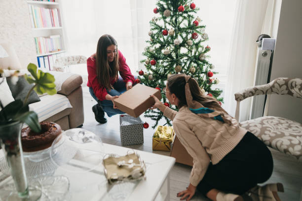 istock Two women placing presents under a Christmas tree 1349465330