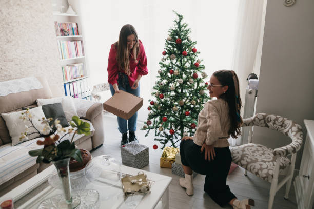 istock Two women placing presents under a Christmas tree 1349465369
