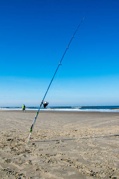 lancer une canne à pêche sur la plage de l’île de borkum en mer du nord - crank bait photos et images de collection
