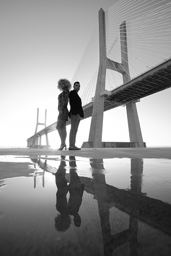 Couple landing in front of the Vasco da Gama Bridge in Lisbon