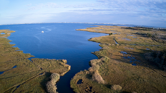 Marshland and recreational boaters in the distance along Barnegat Bay, New Jersey aerial view.