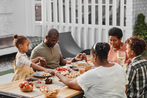 istock Happy Family Saying Grace at Dinner 1349472302