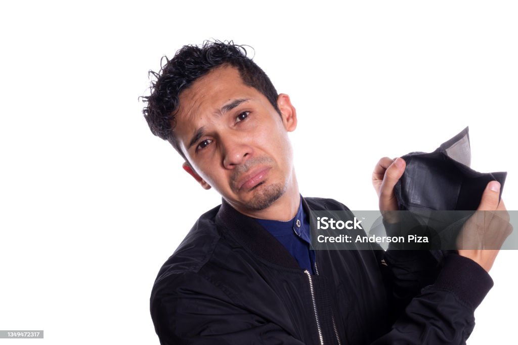 Sad man showing camera his empty wallet, Isolated on white background. Expression of Young adult frustrated because he has no money or savings. Poverty Stock Photo
