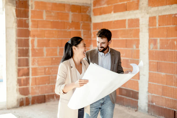 istock Husband and Wife Looking at Blueprints at Construction Sites 1349483100