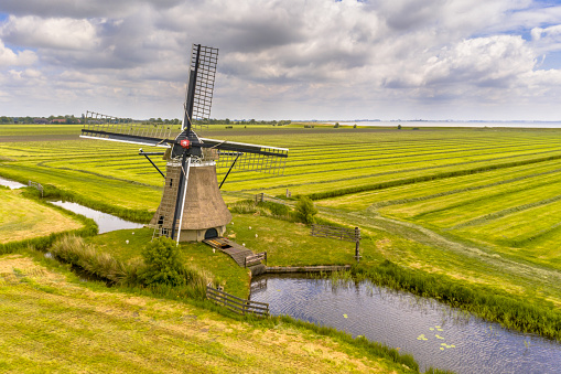 Old wooden windmill in green agricultural grassland. Friesland, the Netherlands.