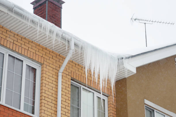 big icicles on the roof of a townhouse on a snowy winter day among thaw - january winter icicle snowing imagens e fotografias de stock