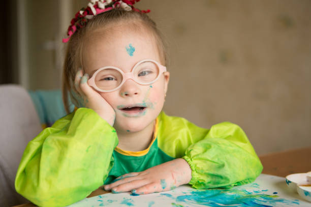 istock Girl with Down syndrome covered in paint when drawing 1349489403