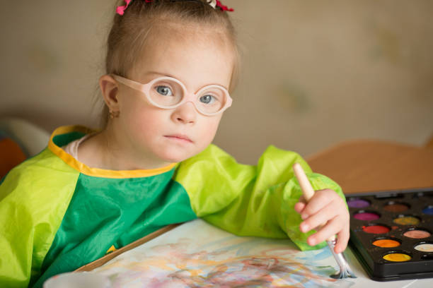 istock Girl with Down syndrome covered in paint when drawing 1349489542