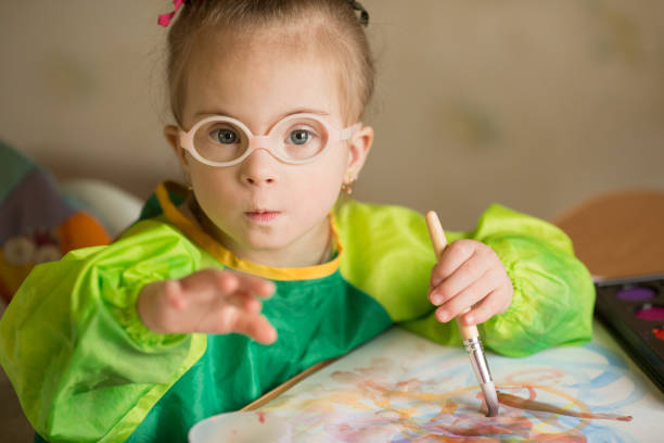 istock Girl with Down syndrome covered in paint when drawing 1349490078