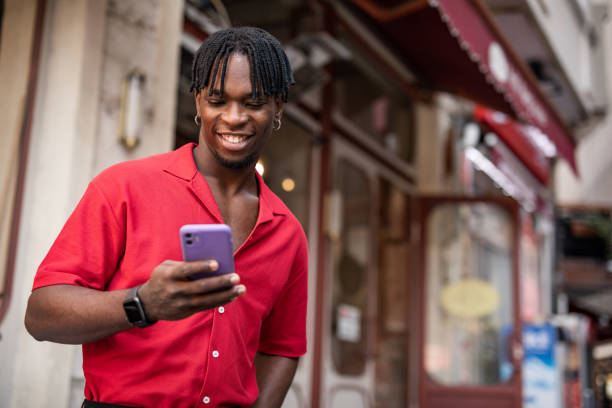 istock Portrait of a handsome afro man using modern contemporary technologies, phone and wifi wireless headphones 1349490095