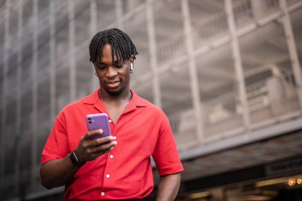 istock Portrait of a handsome afro man using modern contemporary technologies, phone and wifi wireless headphones 1349490096