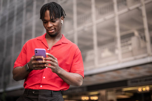 istock Portrait of a handsome afro man using modern contemporary technologies, phone and wifi wireless headphones 1349490097