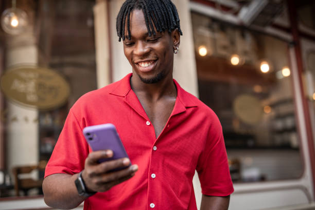 istock Portrait of a handsome afro man using modern contemporary technologies, phone and wifi wireless headphones 1349490100