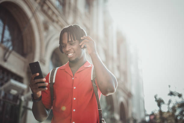 istock Portrait of a handsome afro man using modern contemporary technologies, phone and wifi wireless headphones 1349490111