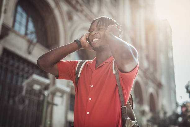 istock Portrait of a handsome afro man using modern contemporary technologies, phone and wifi wireless headphones 1349490112