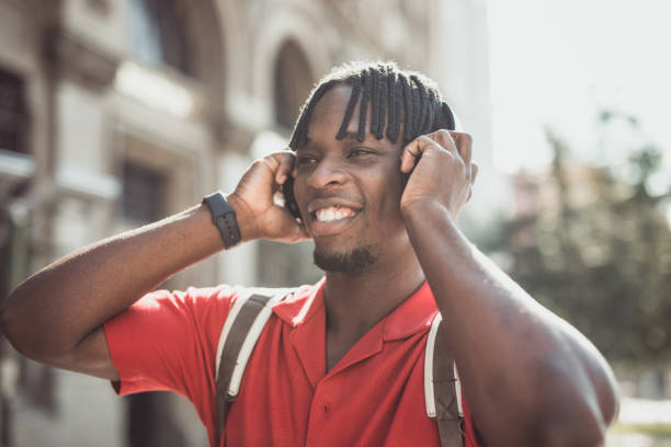 istock Portrait of a handsome afro man using modern contemporary technologies, phone and wifi wireless headphones 1349490117