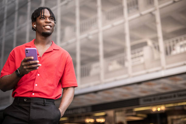 istock Portrait of a handsome afro man using modern contemporary technologies, phone and wifi wireless headphones 1349490118