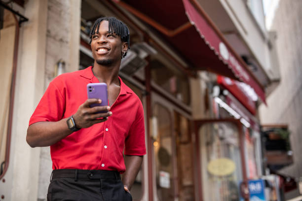 istock Portrait of a handsome afro man using modern contemporary technologies, phone and wifi wireless headphones 1349490130